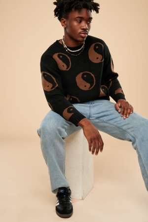 Black Yin Yang Sweater front view of model sitting 